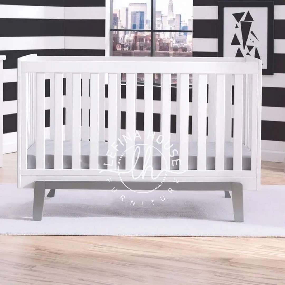 Ranjang Bayi Minimalis Putih dengan Kaki Meruncing gaya Mid-Century Modern.